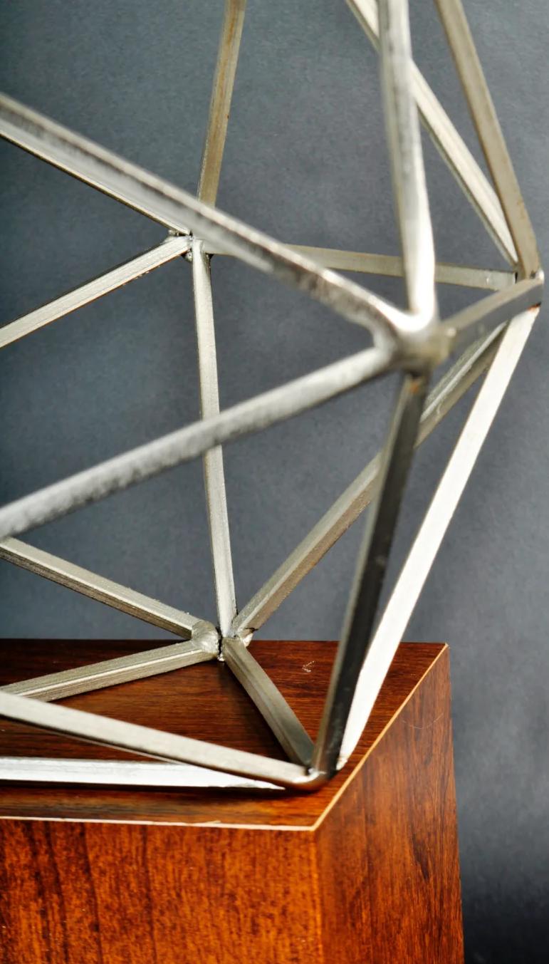 Metal sculpture on wood stand