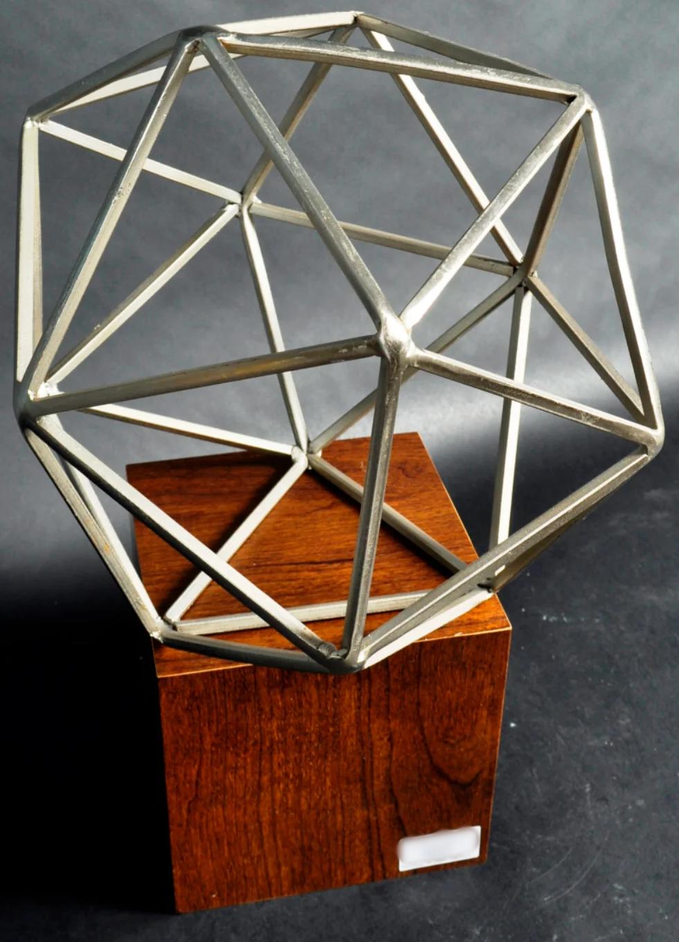 Metal sculpture on wood stand