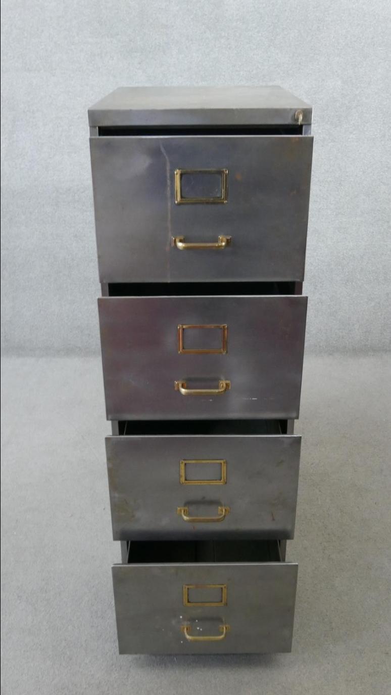 Vintage polished metal filing cabinet with brass fittings.