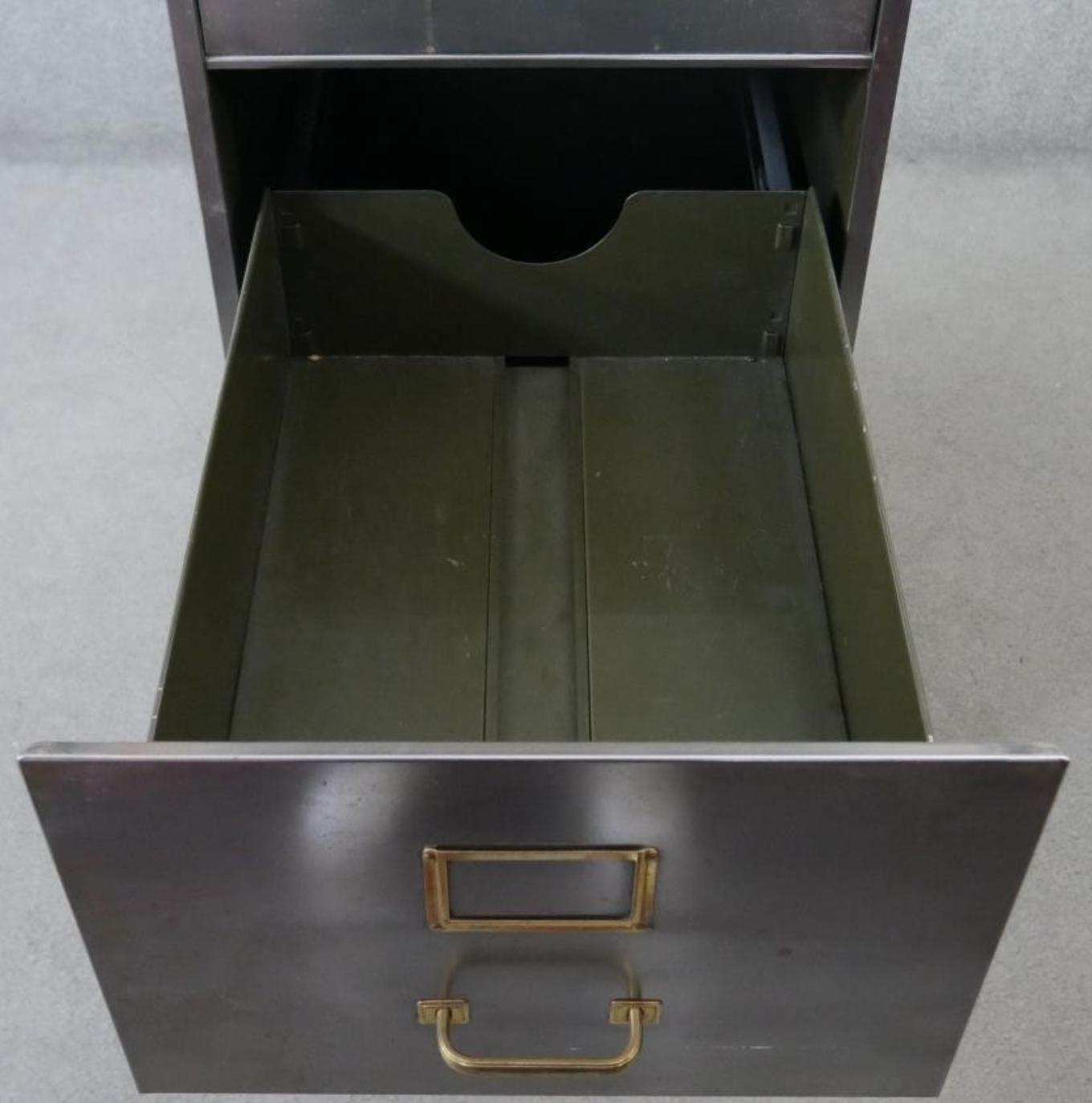 Vintage polished metal filing cabinet with brass fittings.