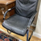 A pair of vintage armchairs in chrome steel and black leather