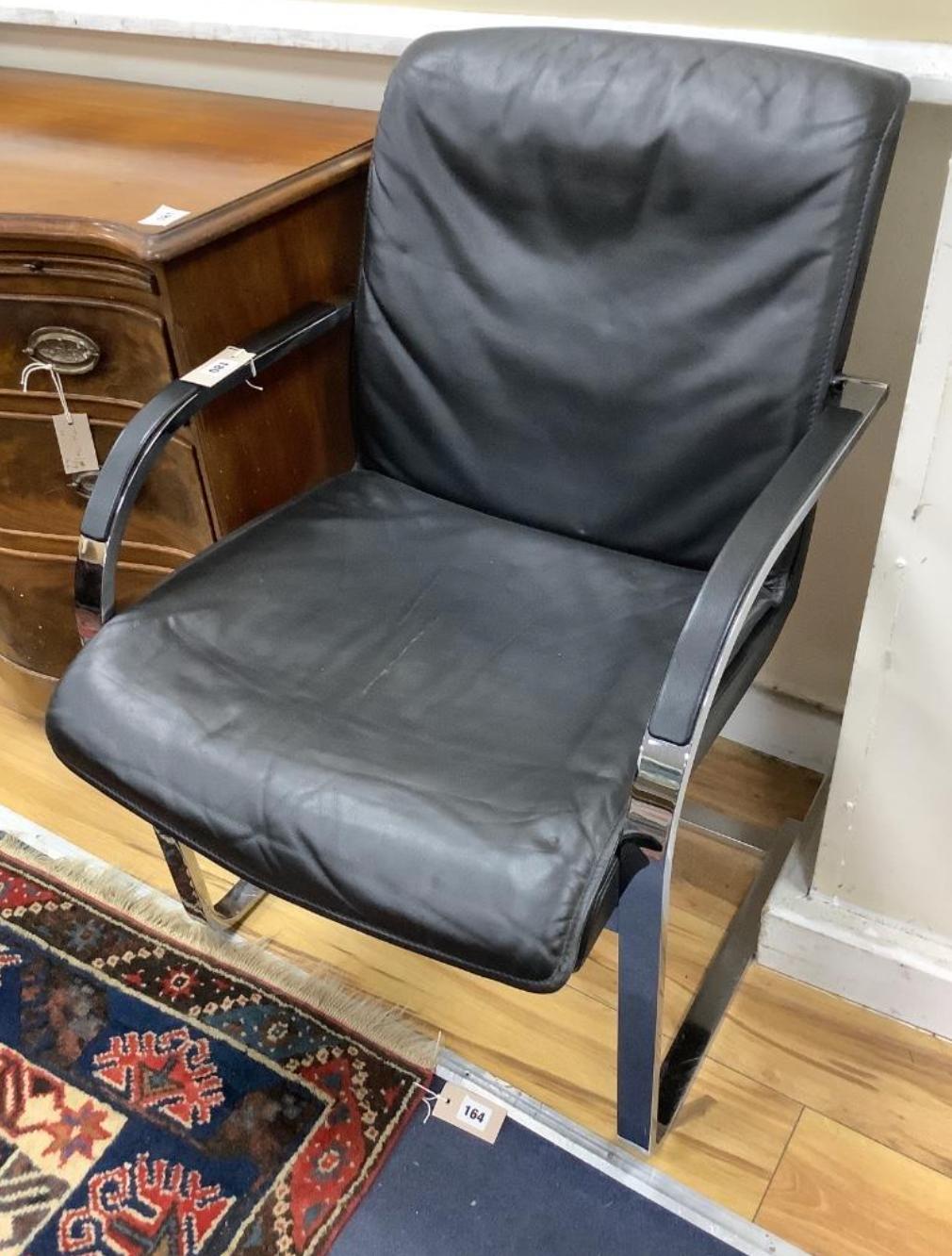 A pair of vintage armchairs in chrome steel and black leather