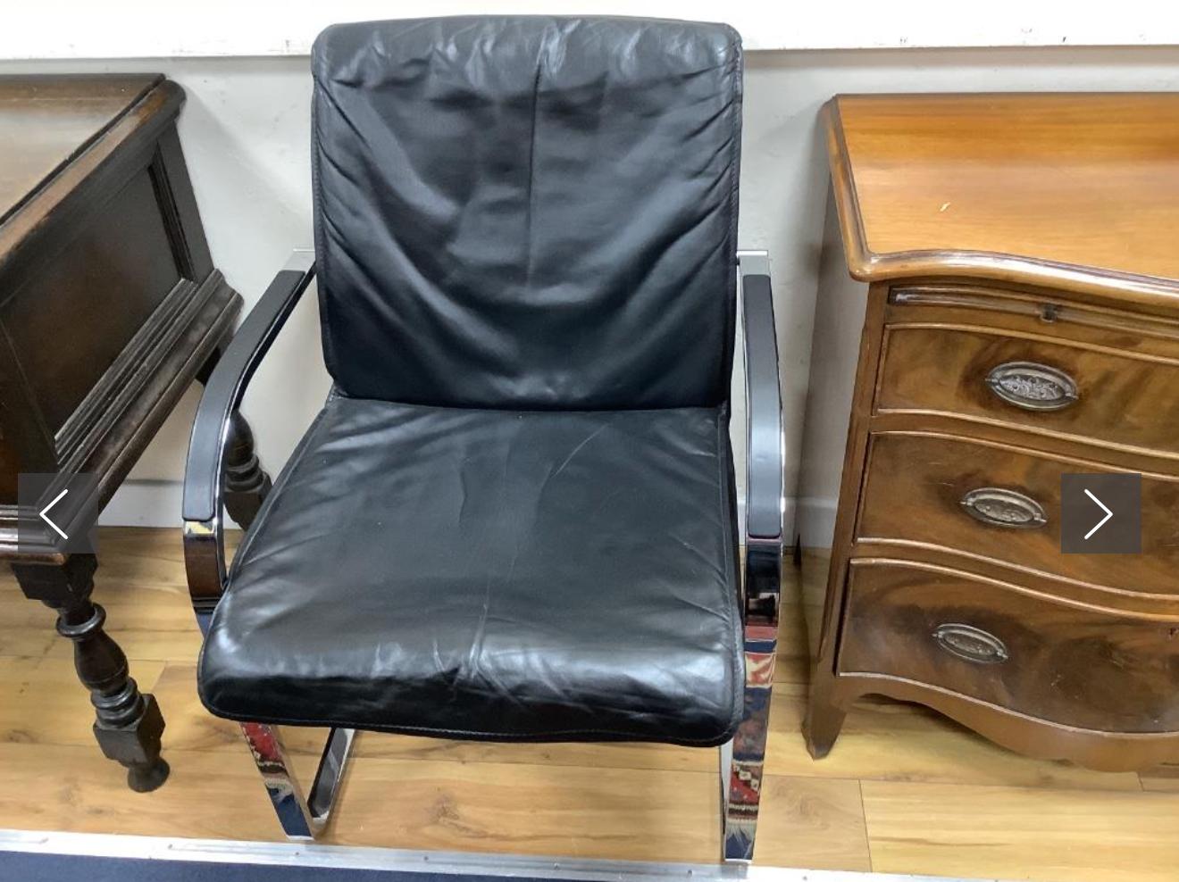 A pair of vintage armchairs in chrome steel and black leather