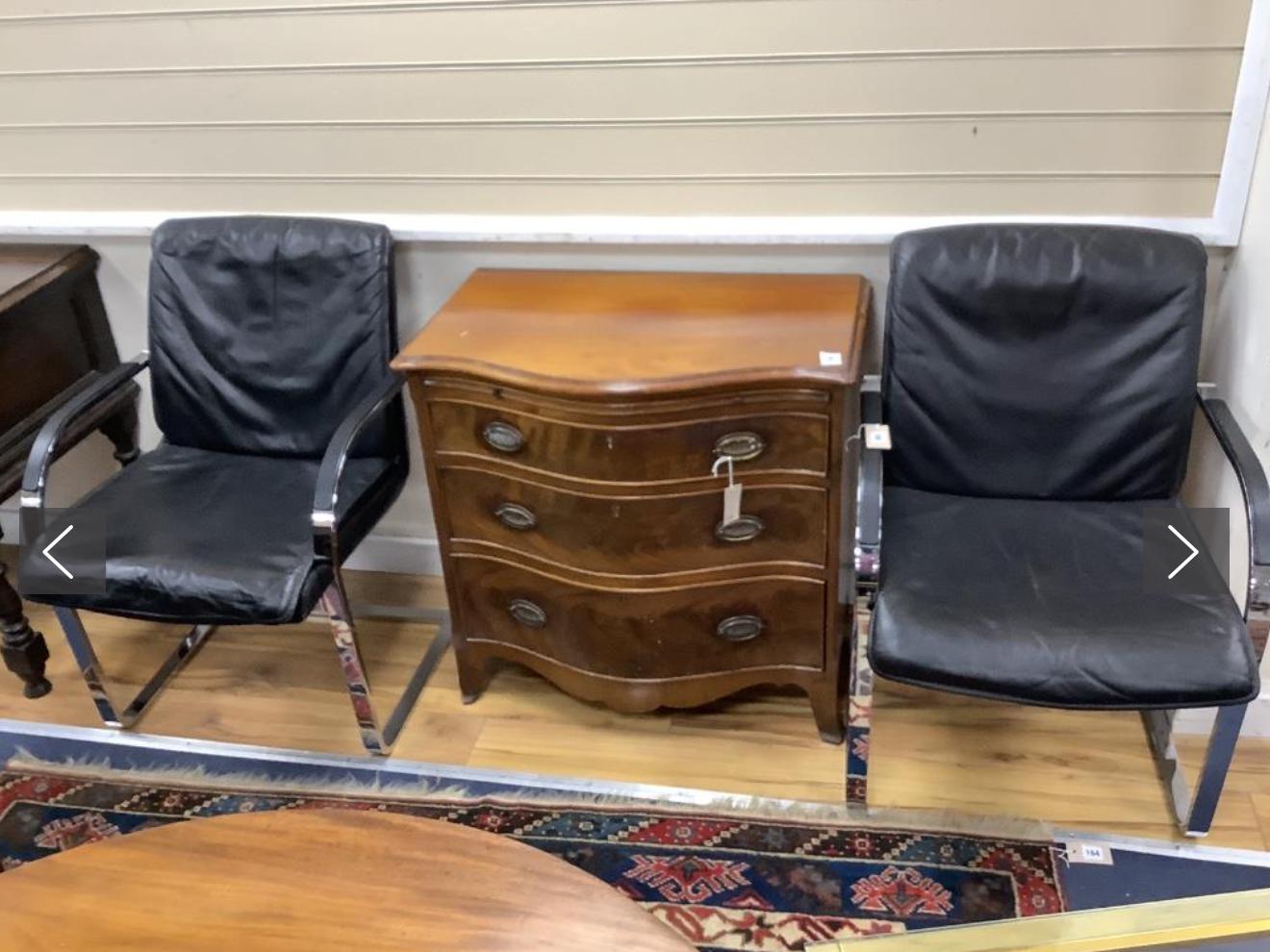 A pair of vintage armchairs in chrome steel and black leather